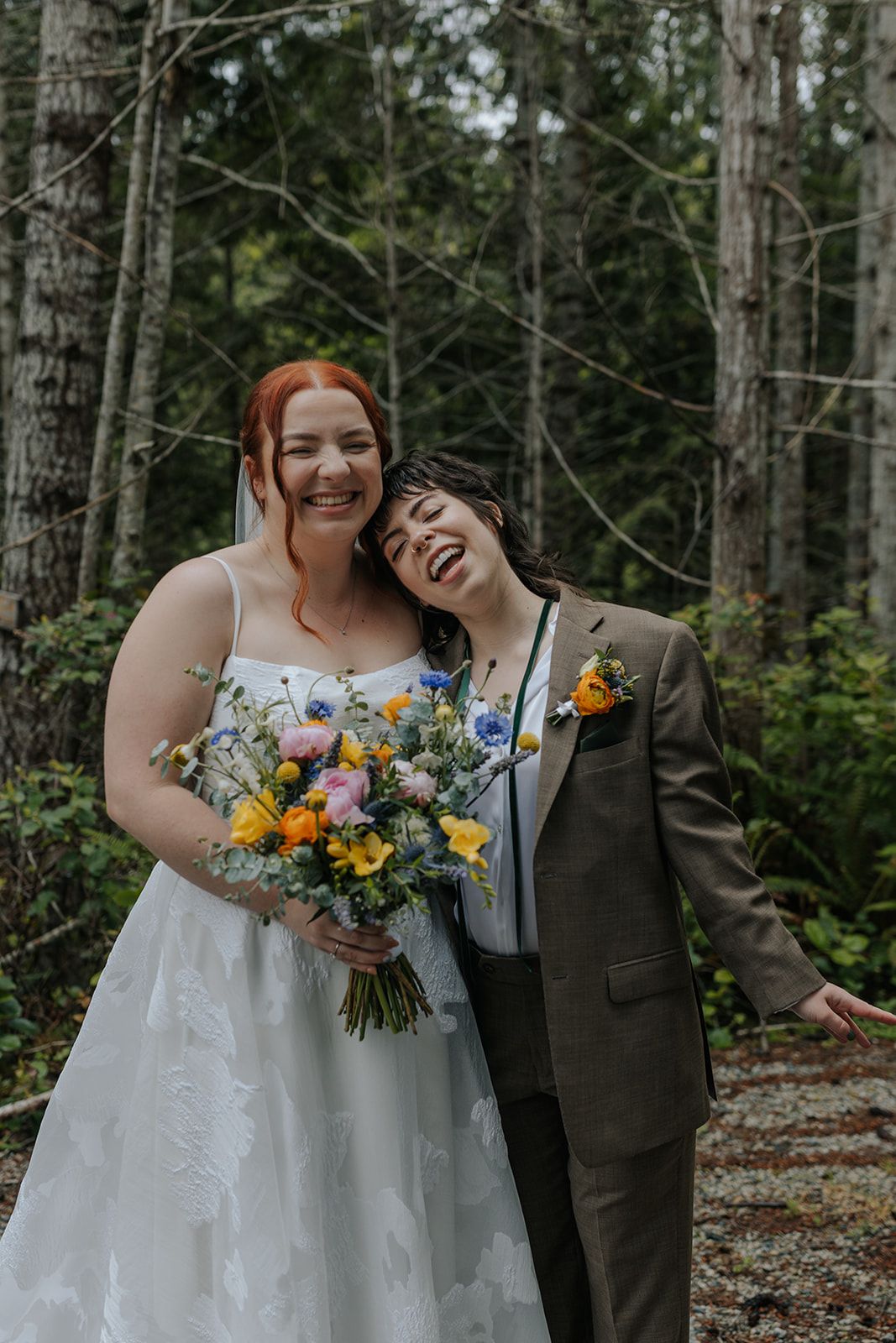 Joyful wedding moments shared between couple during forest photo session with colorful bouquets.