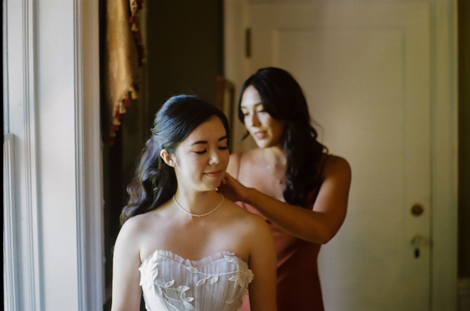 Elegant bridal preparation moments captured in soft natural window light.