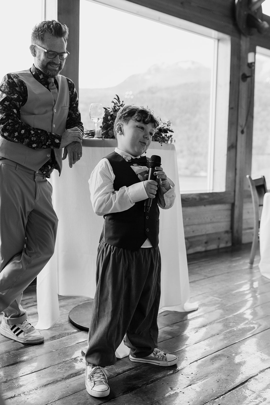 Black and white photo of dancing at a rustic indoor wedding venue.