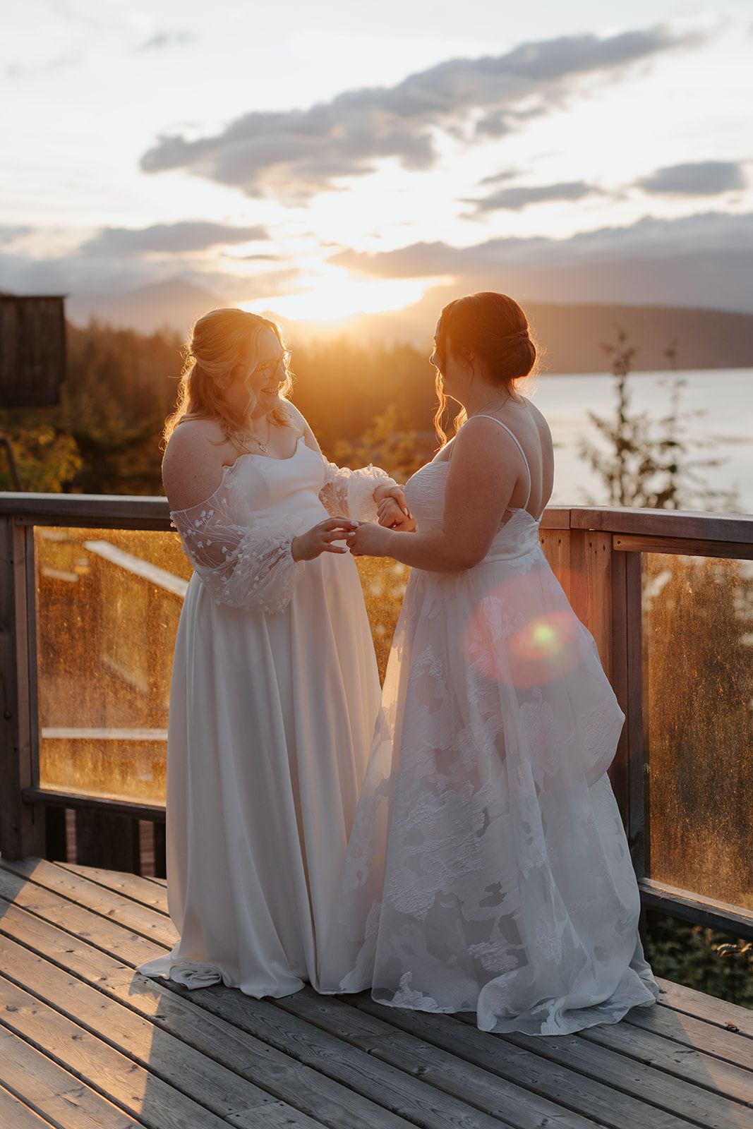 Wedding party members in white dresses gather on deck during golden hour.