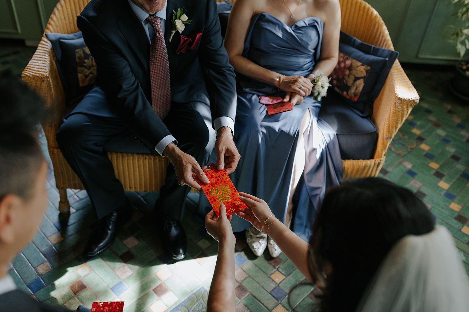 Wedding guests seated in wicker chairs during an outdoor ceremony.