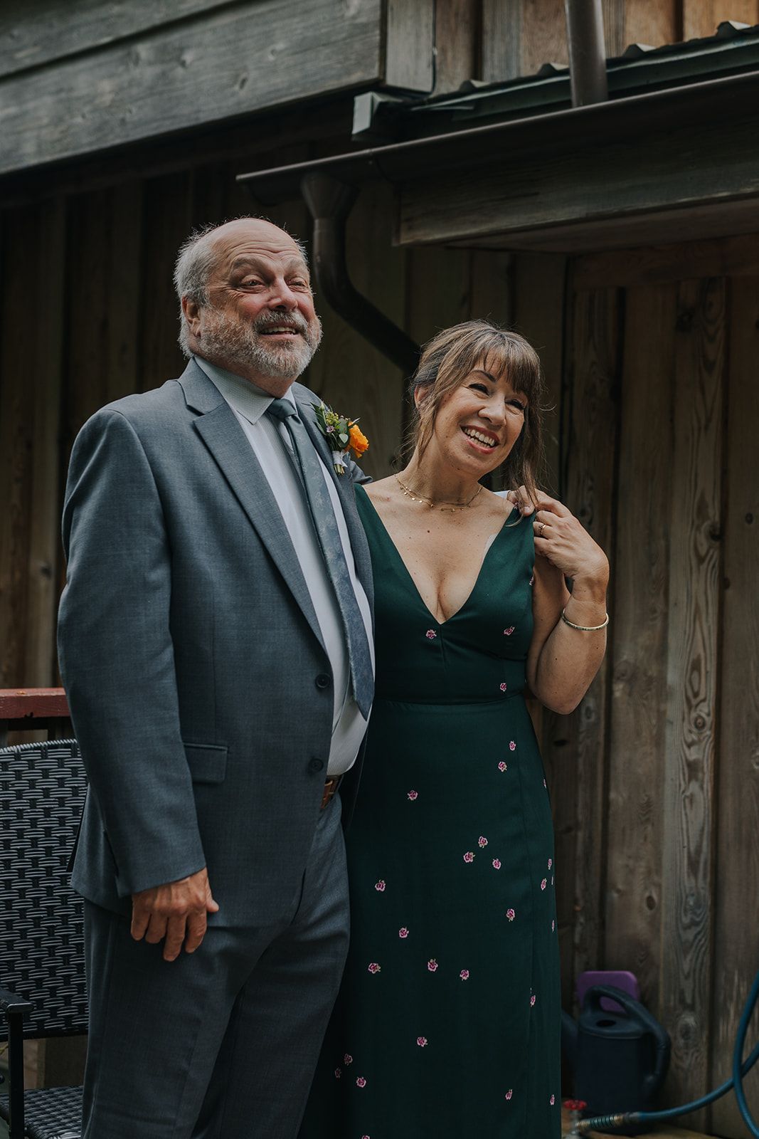 Candid moment between guests in formal attire at outdoor wedding venue.