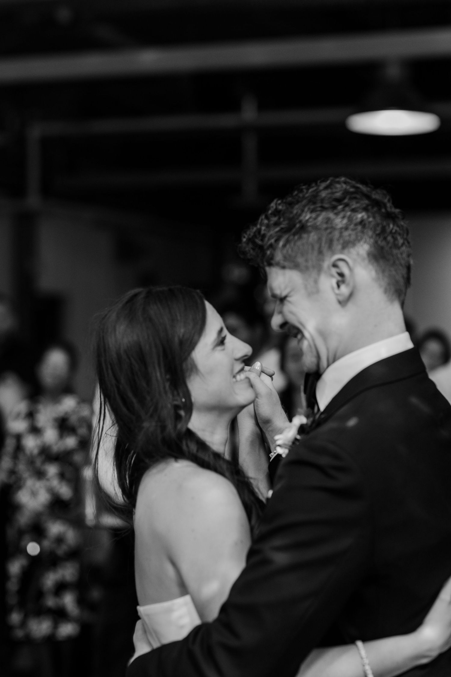 Intimate black and white portrait of a couple sharing a tender moment during their first dance.