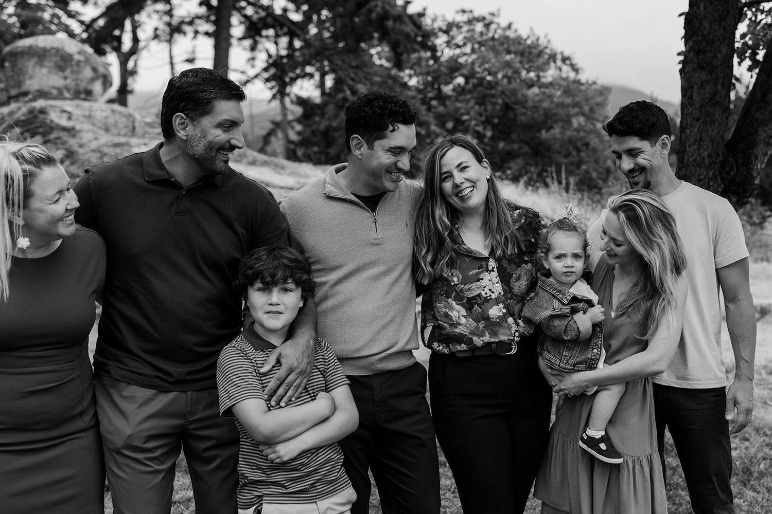Black and white series capturing candid family moments in outdoor setting.
