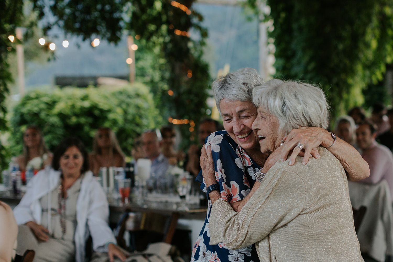 Guests share joyful embraces and emotional moments during a celebration event.