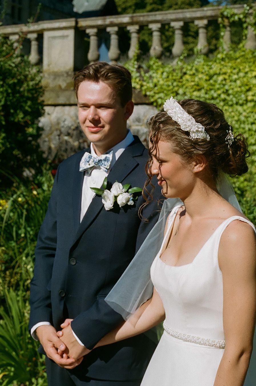 Wedding couple sharing joyful moment during outdoor ceremony.