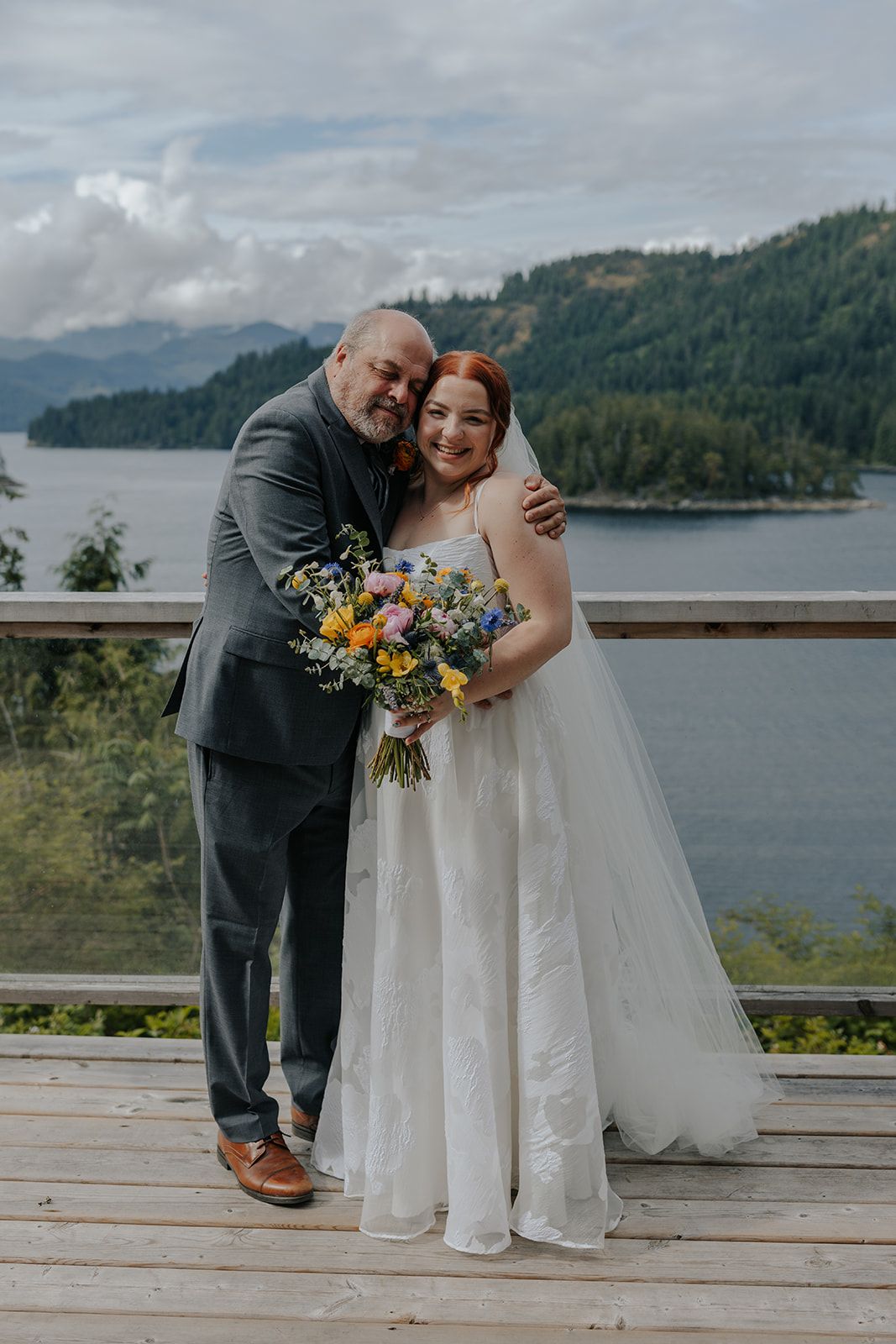 Intimate wedding moments captured on scenic overlook deck with mountain lake views.