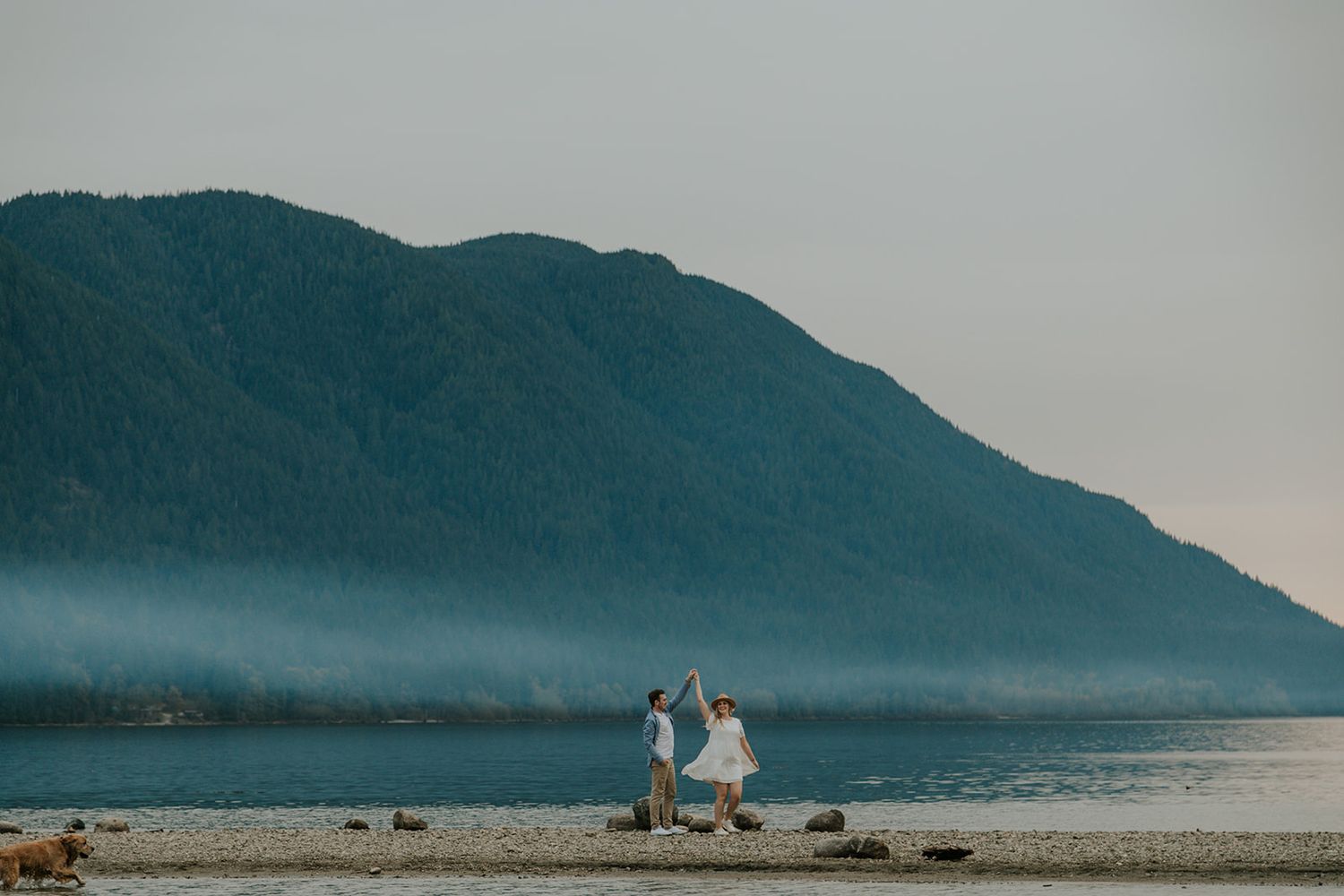 A scenic mountain landscape with water and fog in the distance.
