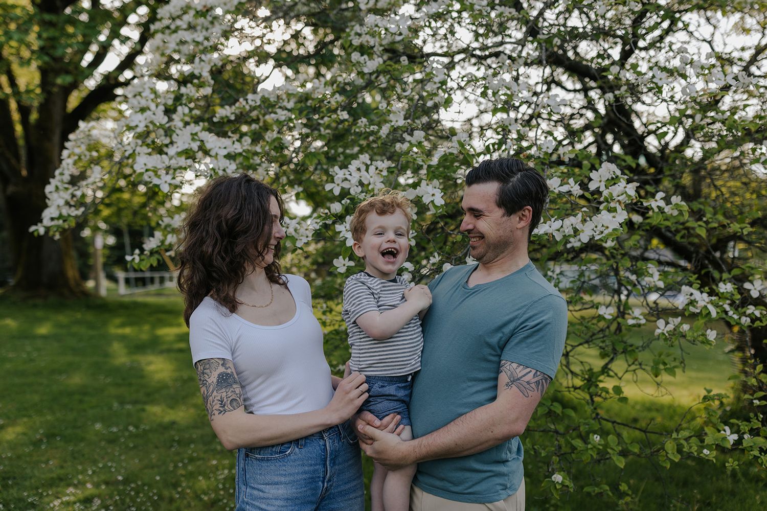 Family enjoying playful moments together in blooming spring garden.