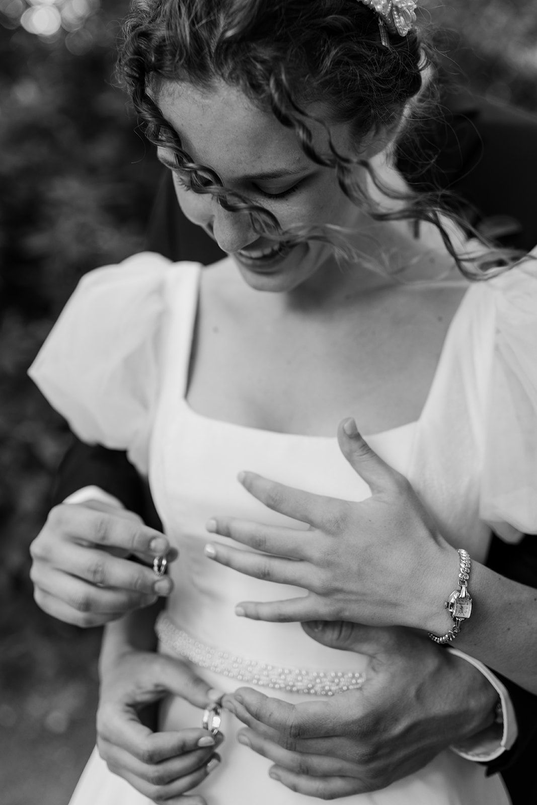 Black and white close-up shots of hands examining wedding jewelry and details.