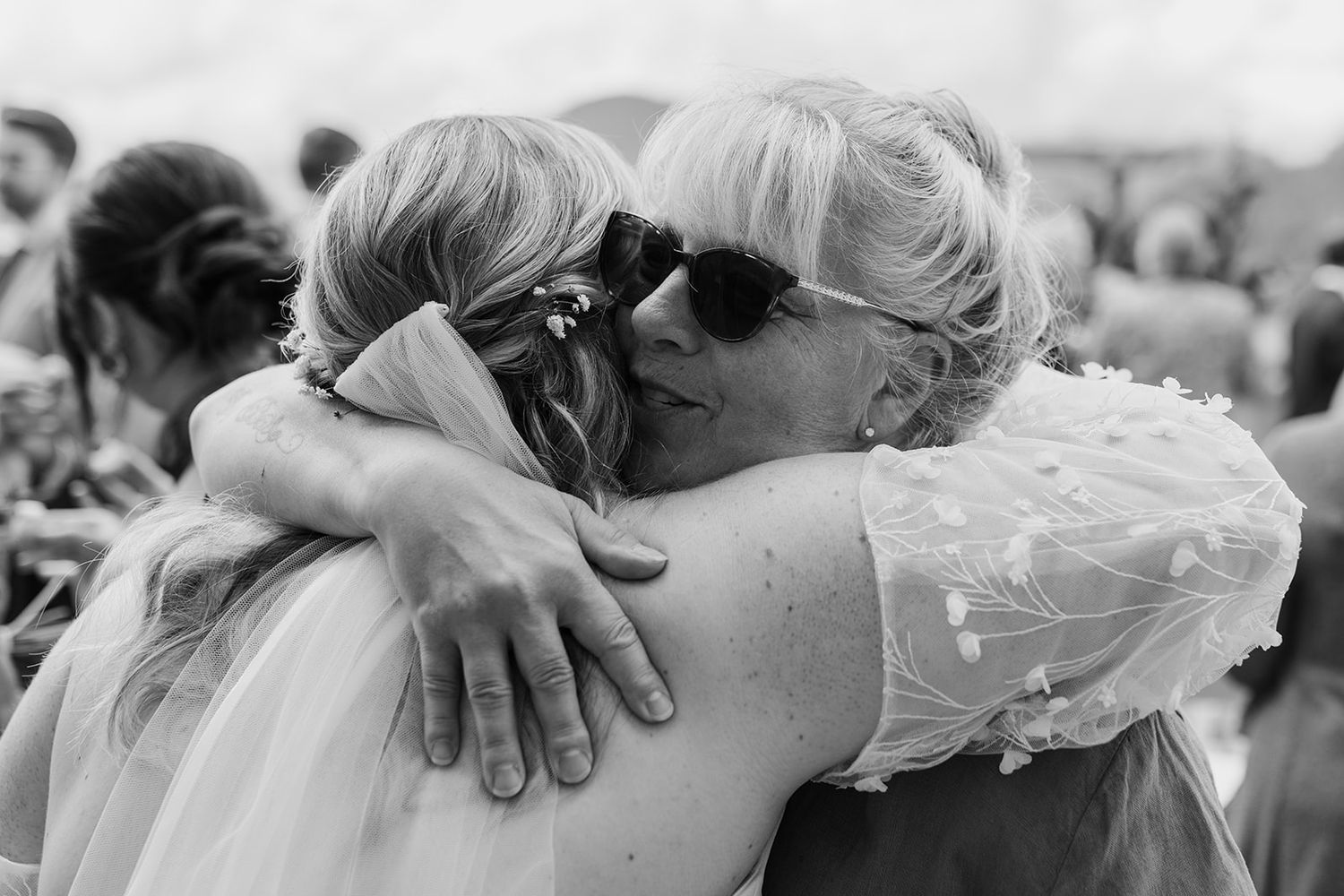 Emotional embraces shared between wedding guests during celebration.