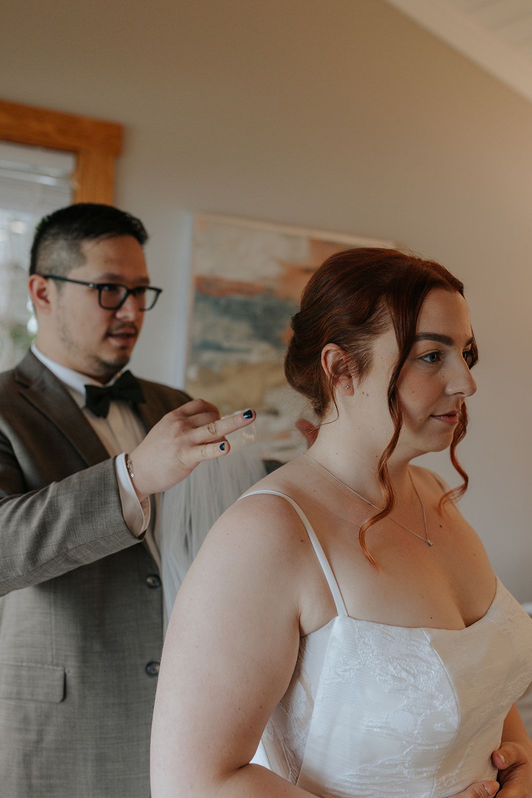 Final wedding preparations with elegant hair styling in a sunlit room.