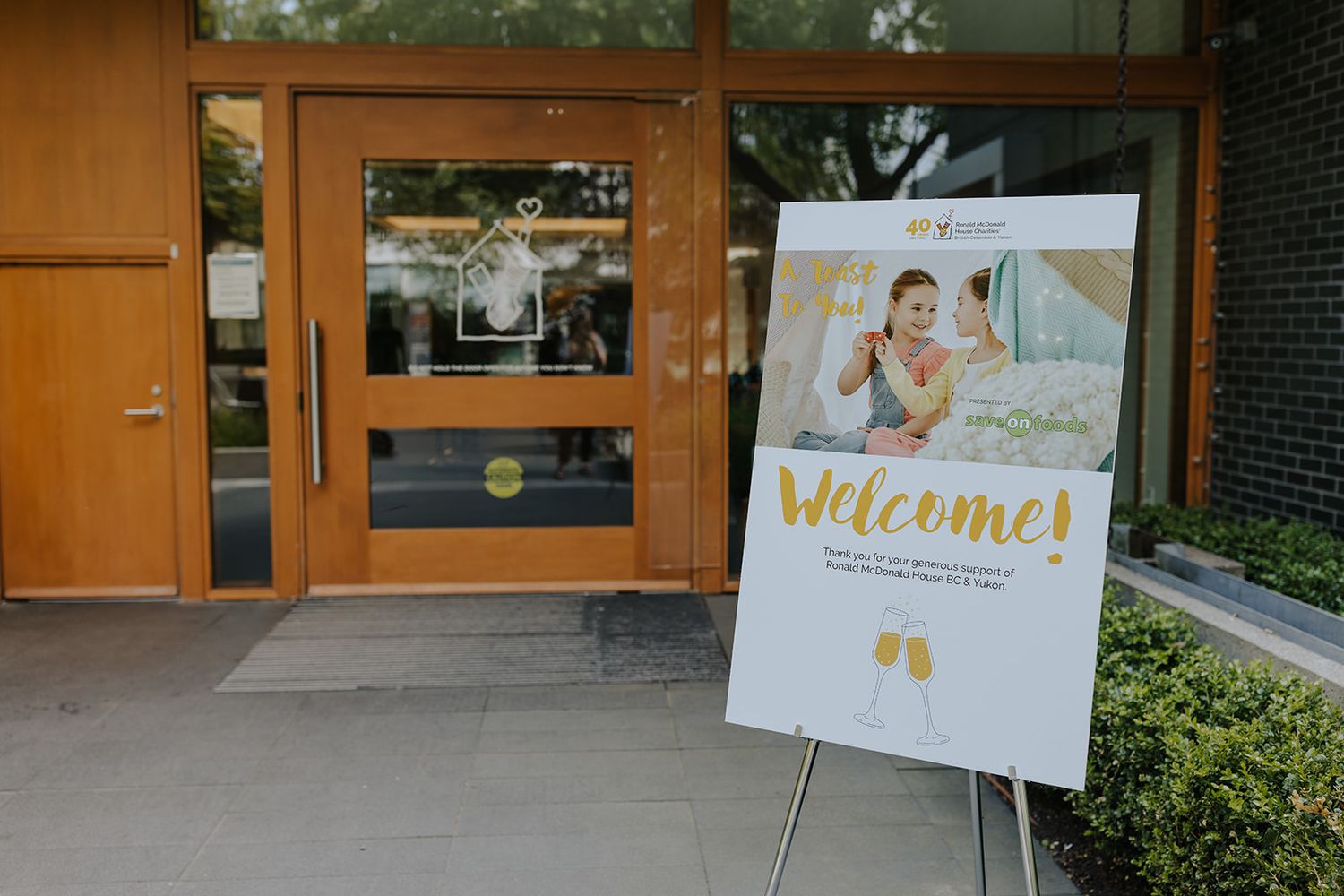 Welcome signs and decorative displays greet guests at an event entrance.