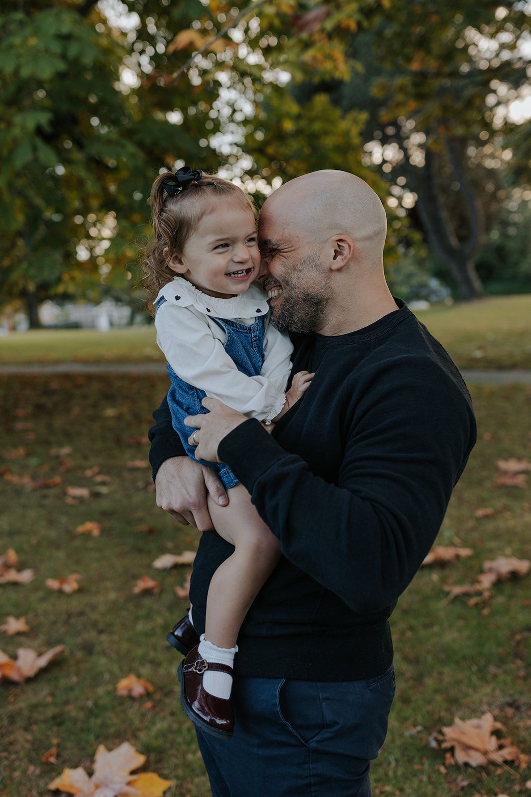 Tender autumn moments between parent and child in park setting.