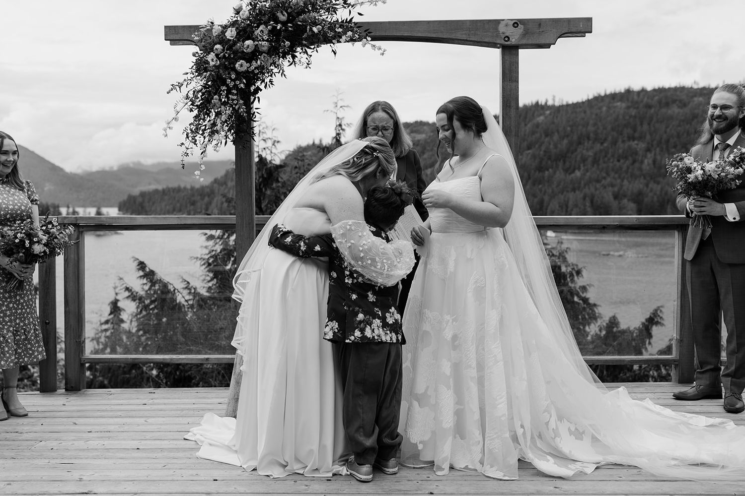 Close-up details of white wedding dresses during an outdoor ceremony.