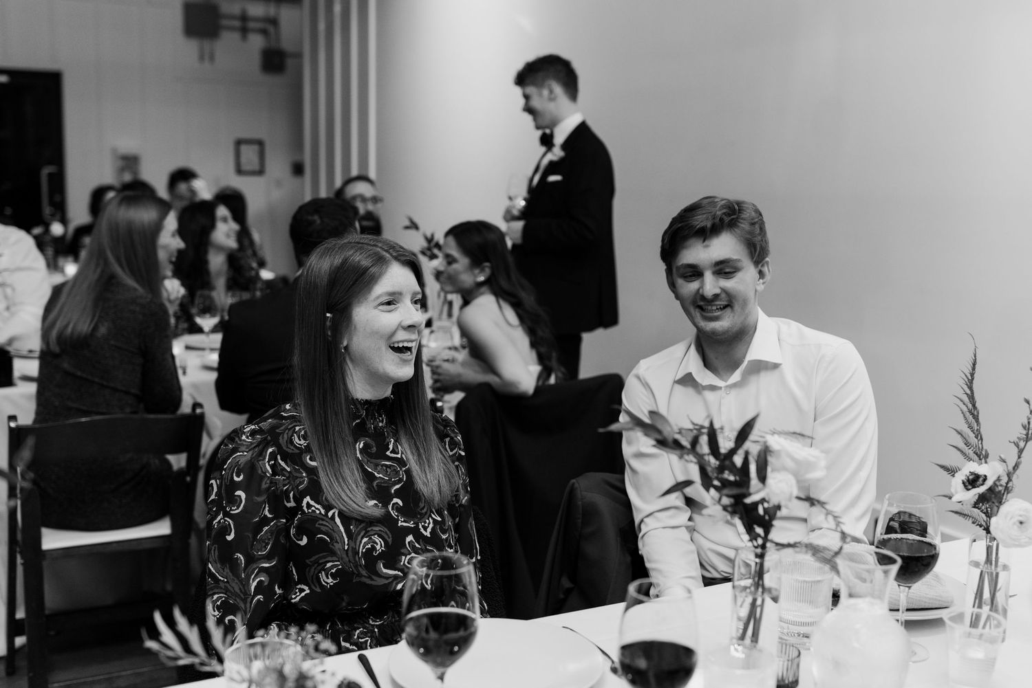 Black and white wedding reception photos showing guests dining and socializing at decorated tables.