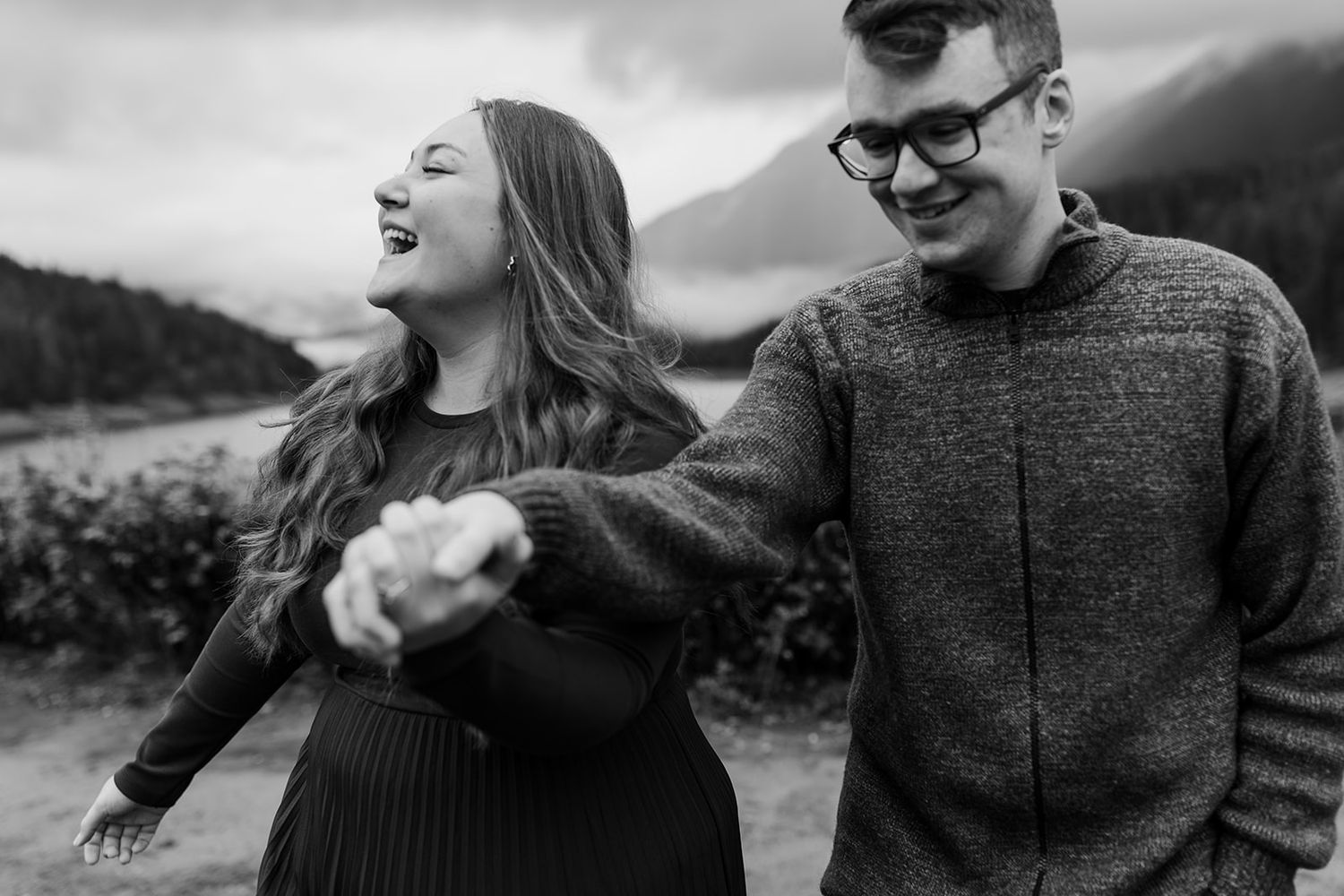 A joyful moment shared between two people outdoors with mountains in the background.