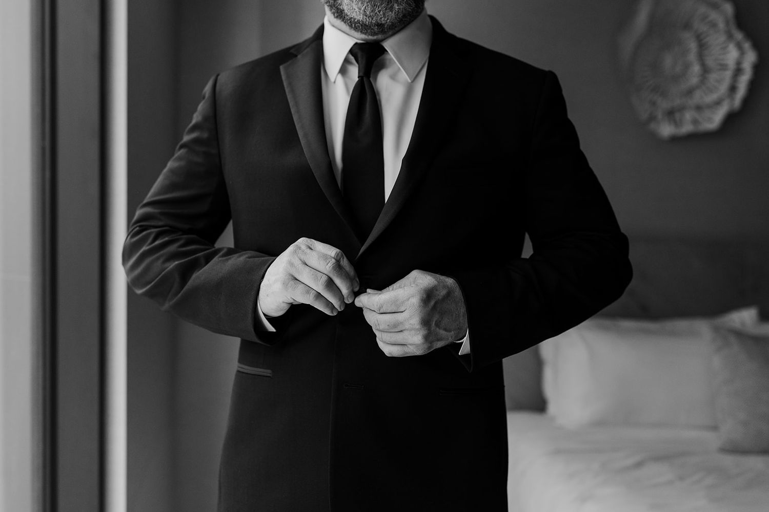 Black and white detail shots of formal menswear and suit preparations.