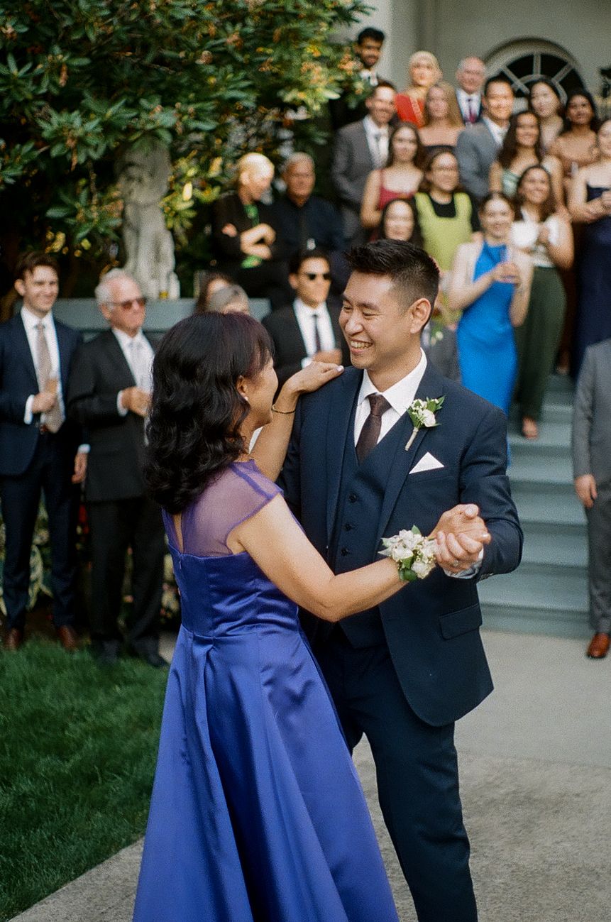 Wedding celebration with guests dancing and enjoying festivities on outdoor steps.