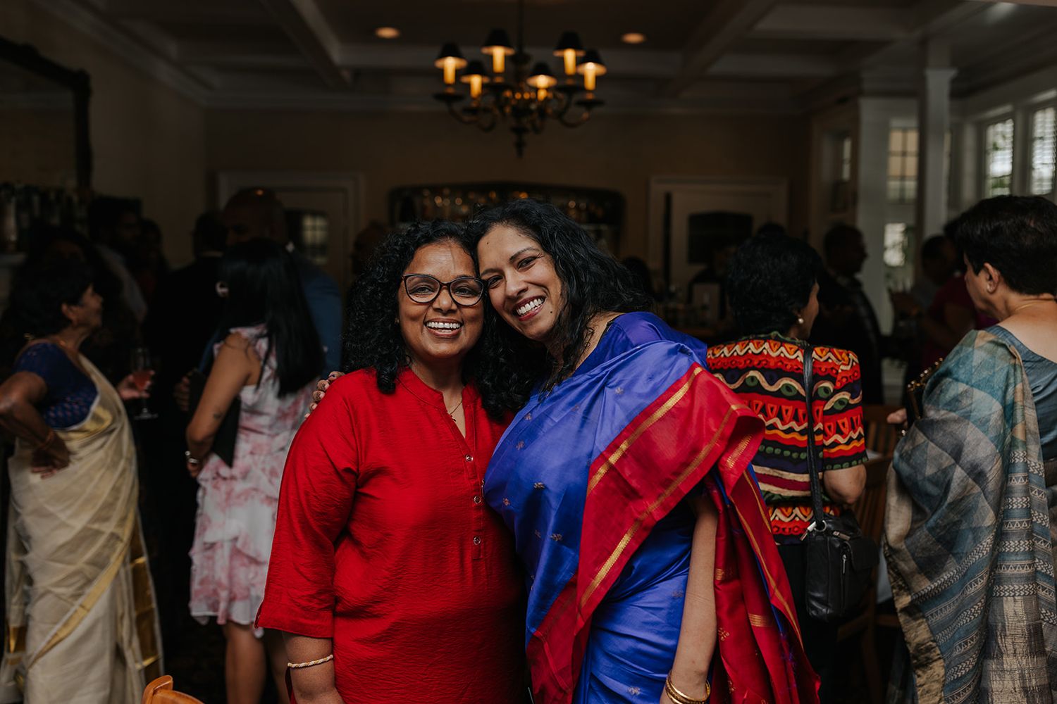 A festive gathering shows people mingling in colorful traditional attire.