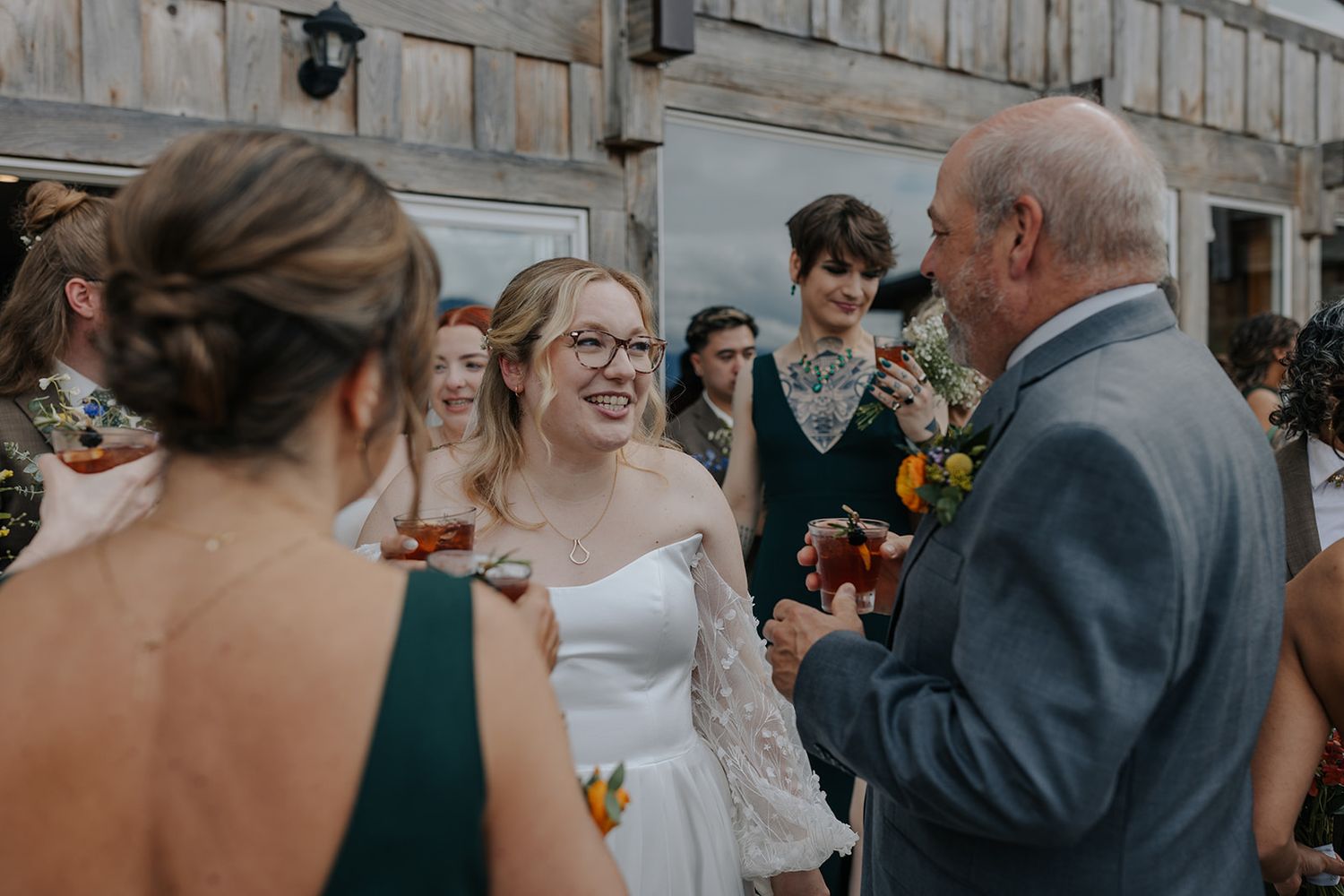 Wedding guests gather and celebrate in rustic wooden venue.