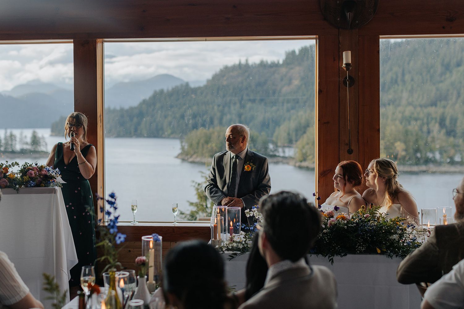Wedding reception venue with panoramic mountain and lake views through large windows.