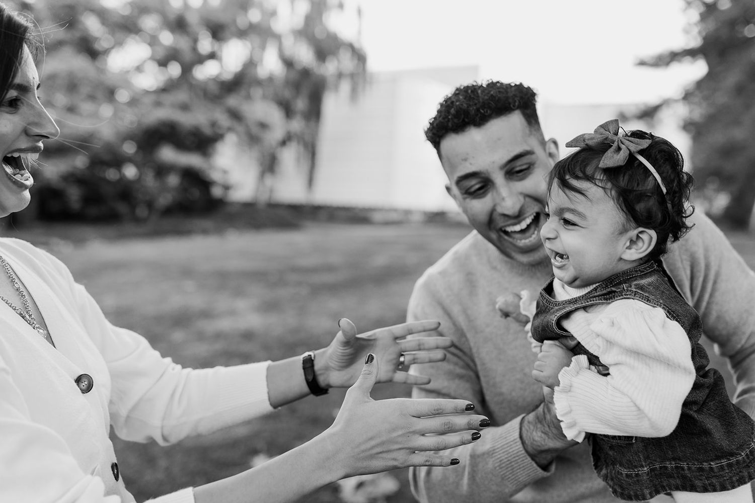 Black and white series showing joyful family moments and embraces outdoors.