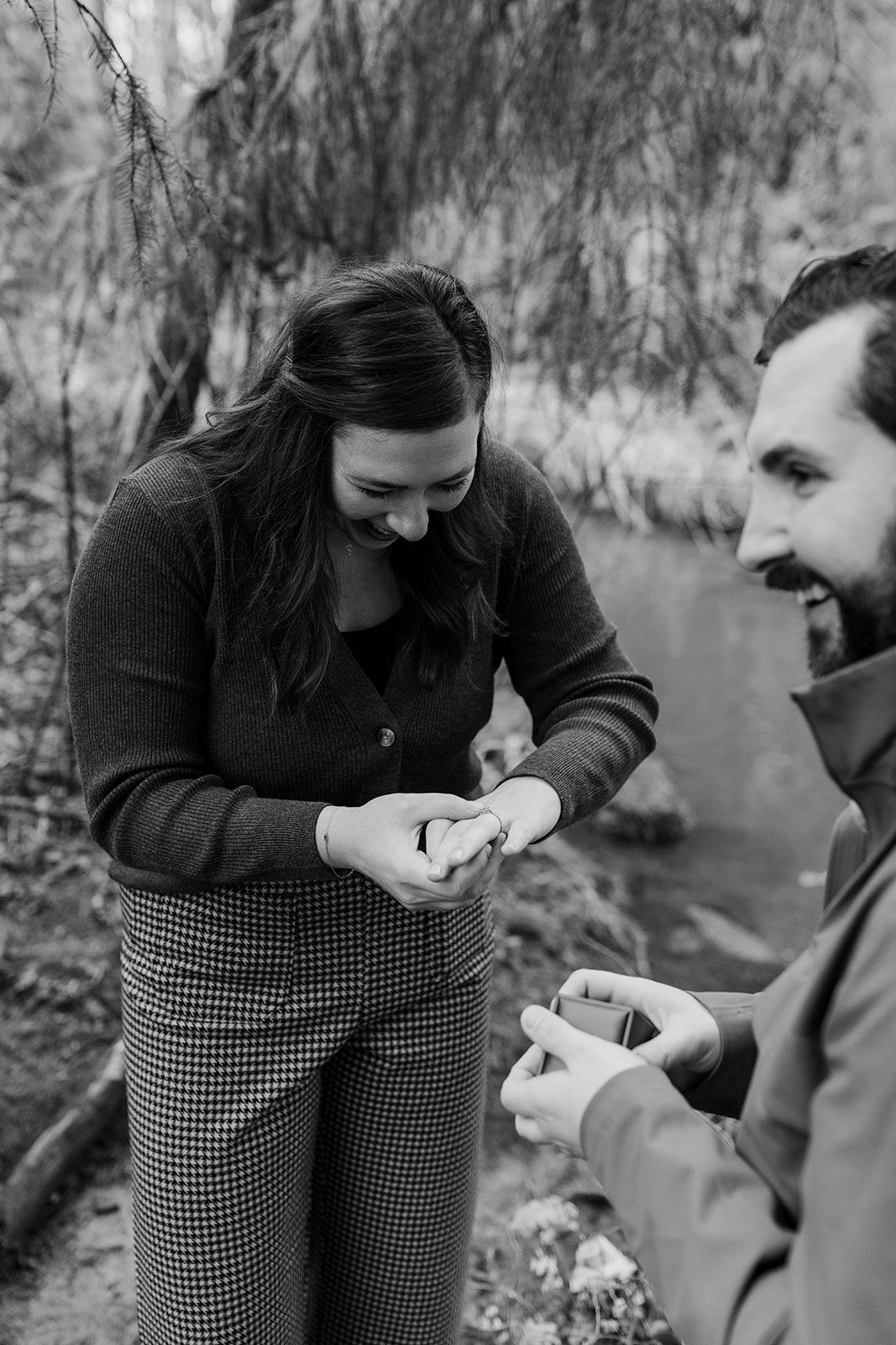 A couple shares an emotional moment while exchanging rings in a black and white photo series.