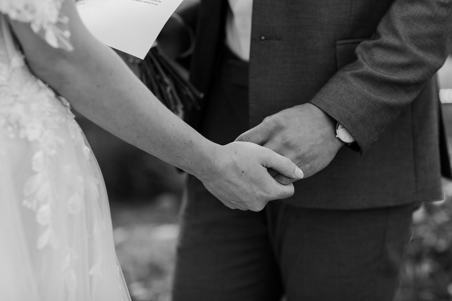 Close-up of hands during wedding ceremony exchange.