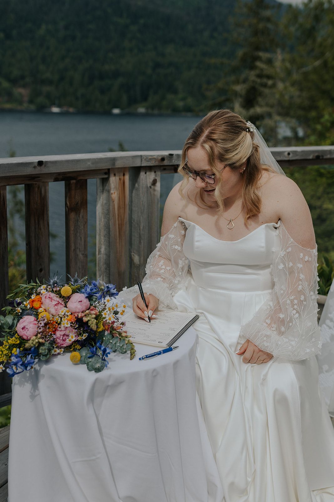 Wedding documents being signed with colorful floral arrangements decorating the table.