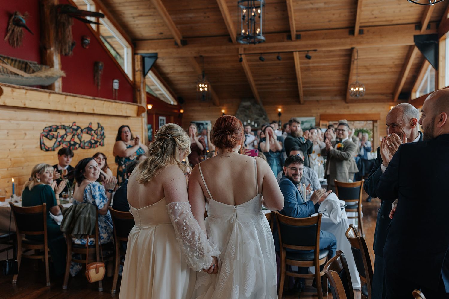 Wedding celebration inside a rustic wooden venue with exposed beam ceiling.