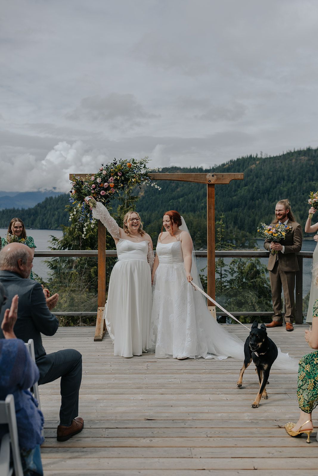 Photographers capture a wedding ceremony against a stunning mountain backdrop.