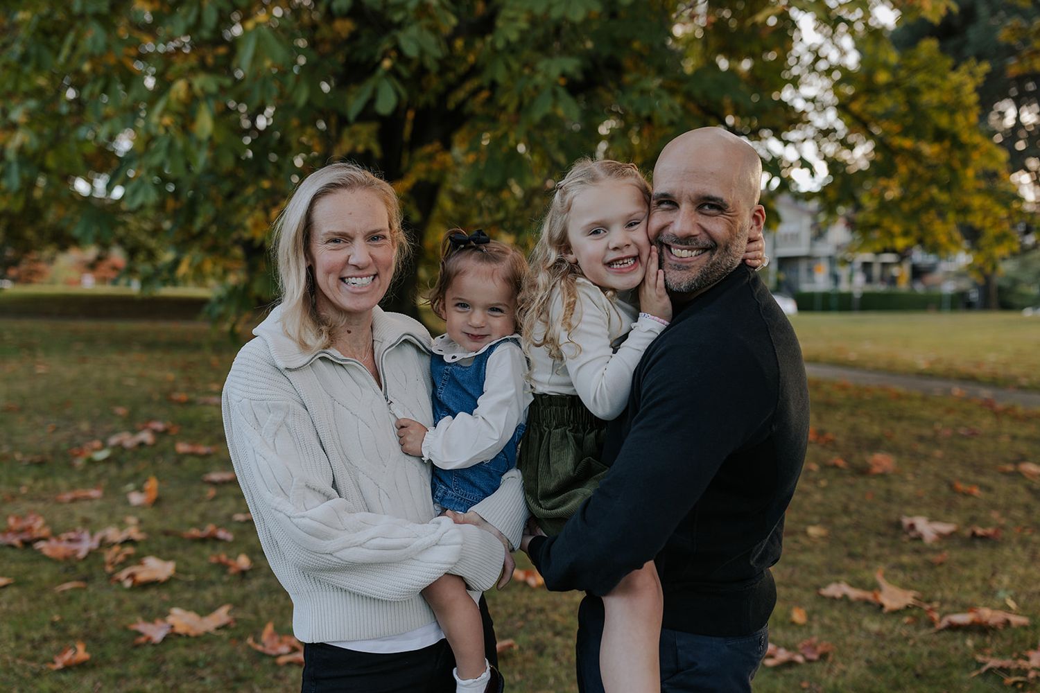 Family sharing joyful moments together on autumn day in park.