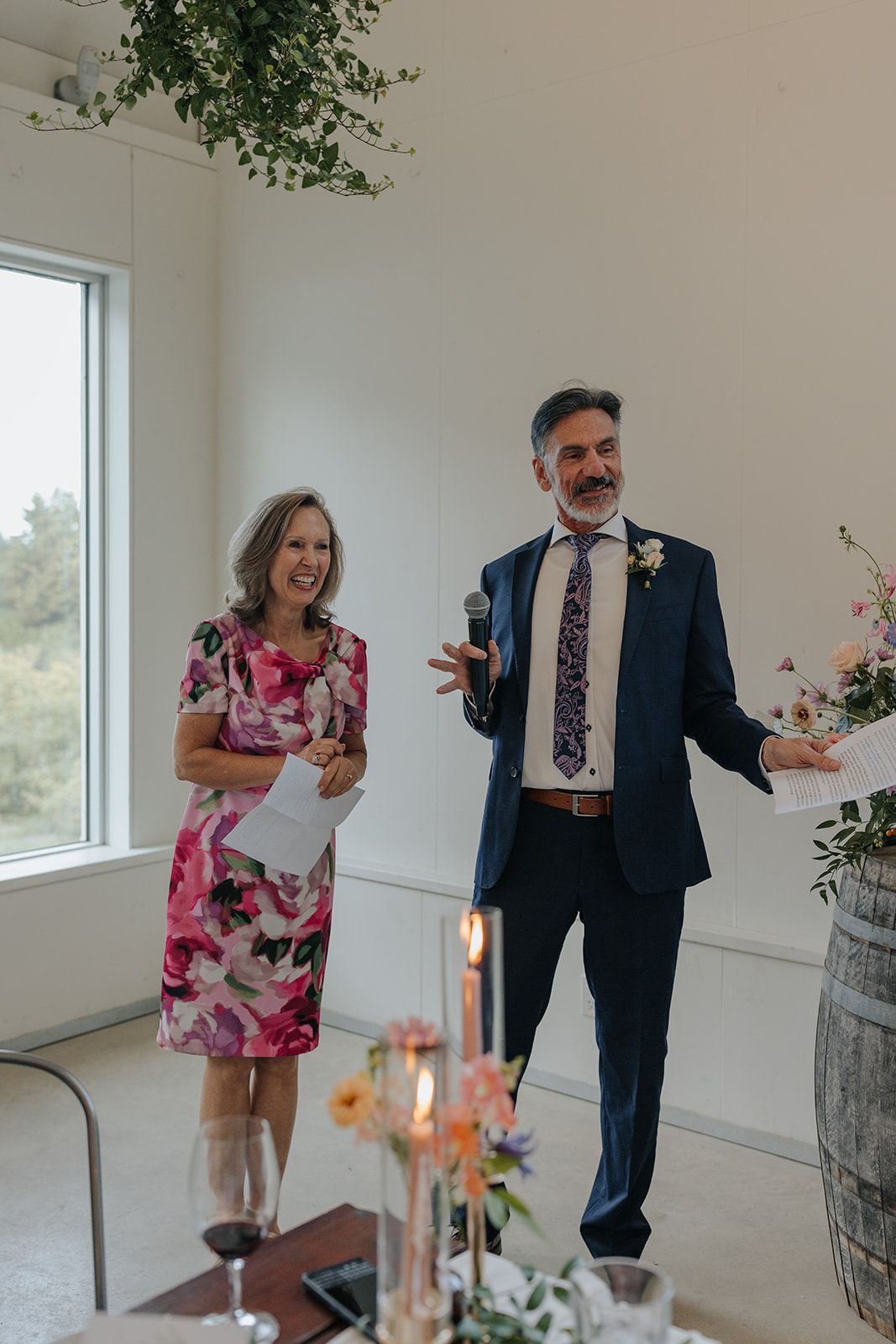 A couple dances playfully in a bright white room with large windows.