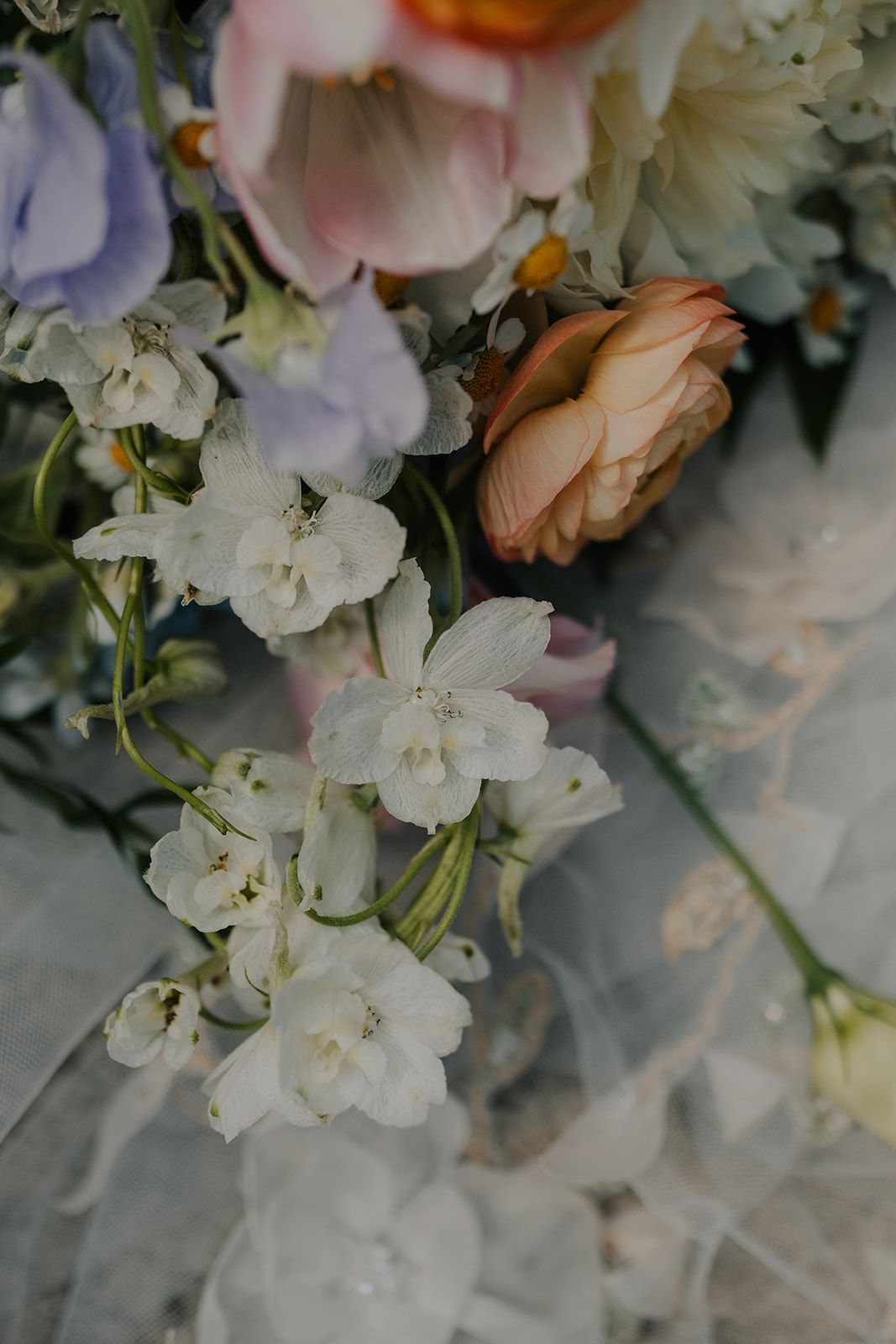 Delicate white and peach floral arrangement with roses and soft petals.