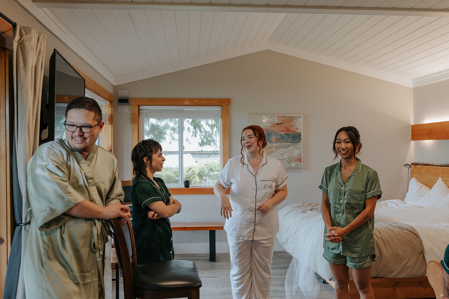 Wedding party members in green dresses and white attire share joyful moments during preparation.