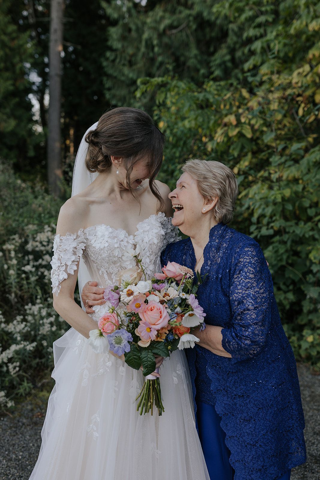 Wedding party members sharing intimate moment with pink floral bouquet.