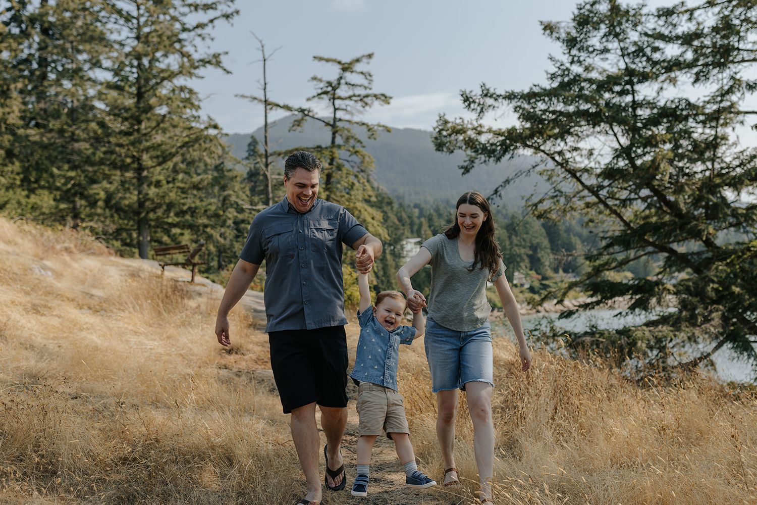 Family walking together on scenic mountain trail during golden hour.