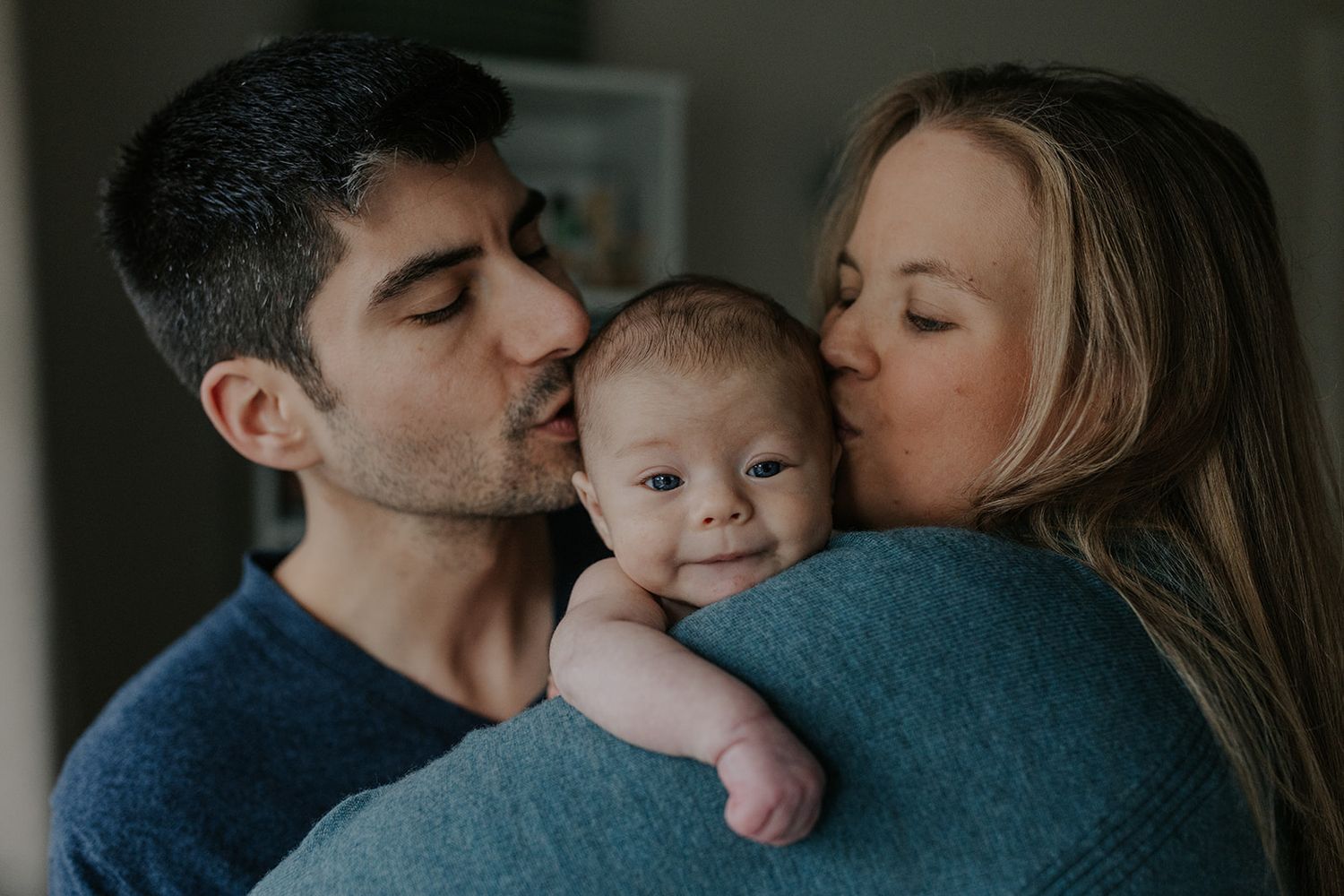 Tender family moments captured in moody indoor lighting.