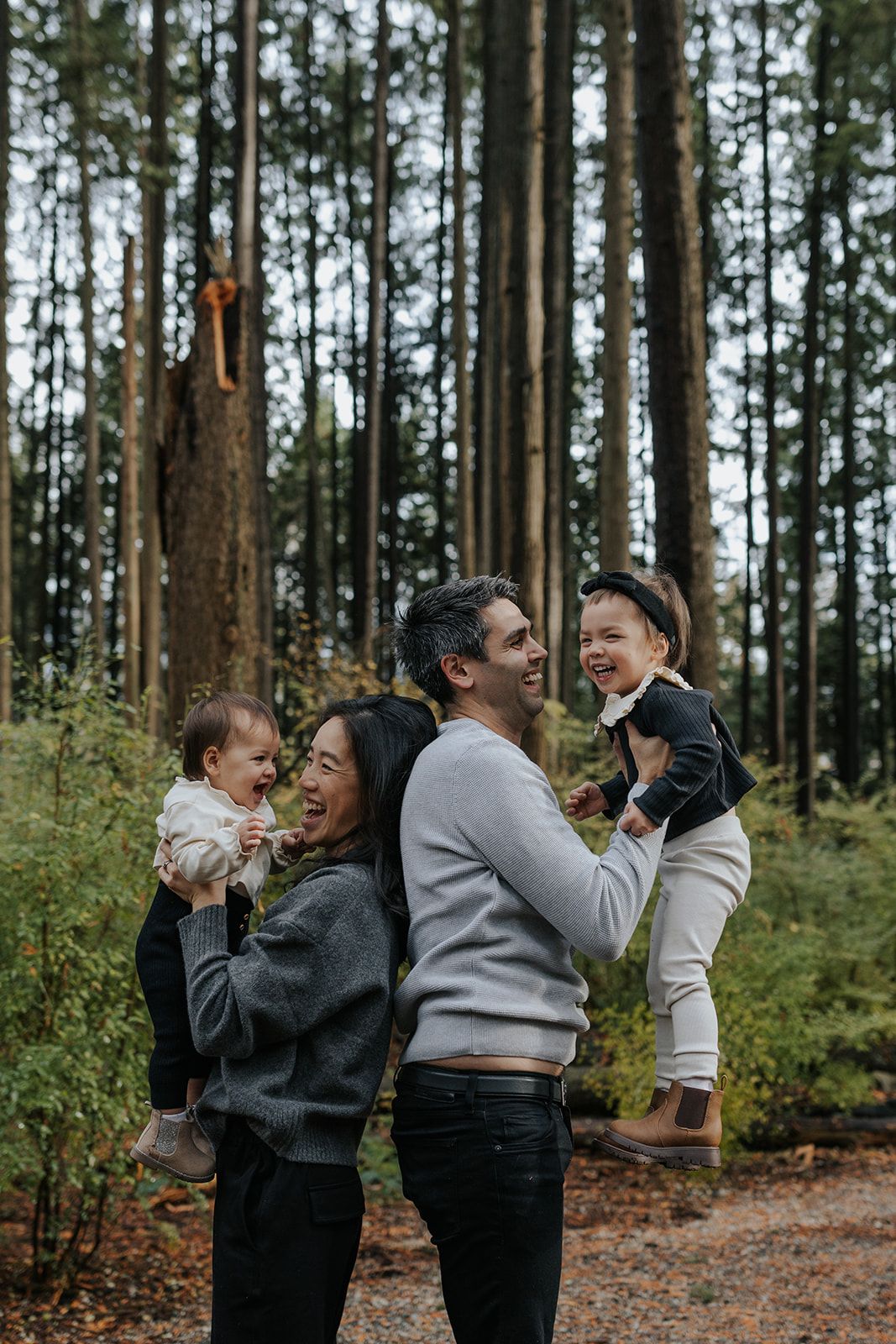 Candid moments of laughter and joy between people in a pine forest.