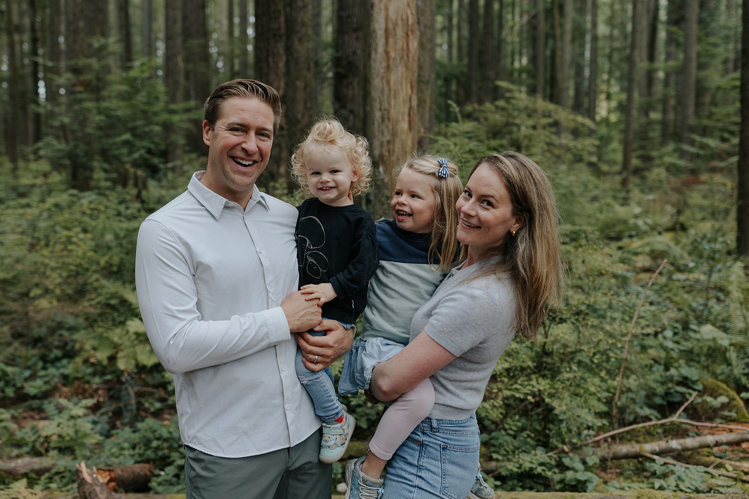 A family of four enjoys quality time together in a lush forest setting.