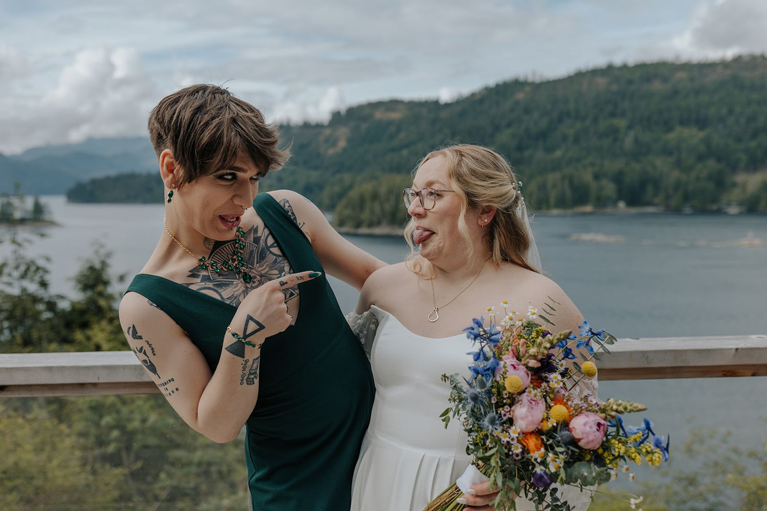 Joyful wedding party interactions captured on deck overlooking serene mountain lake.