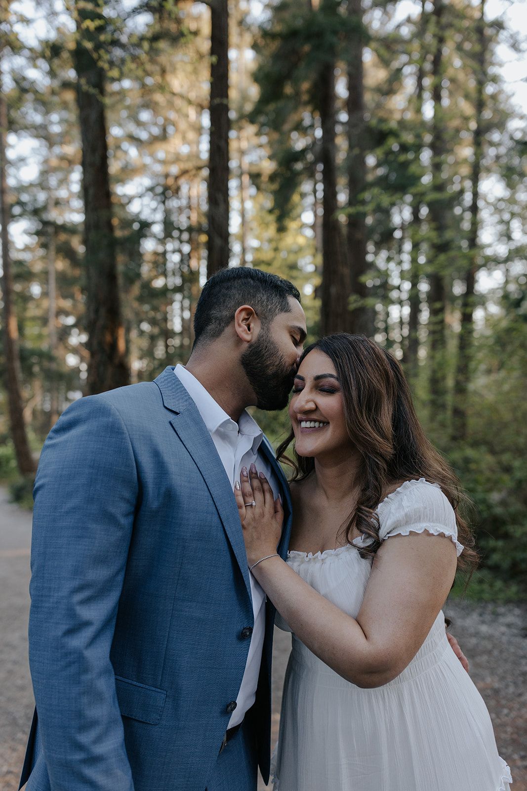 Couple sharing joyful moments together in a forest setting.