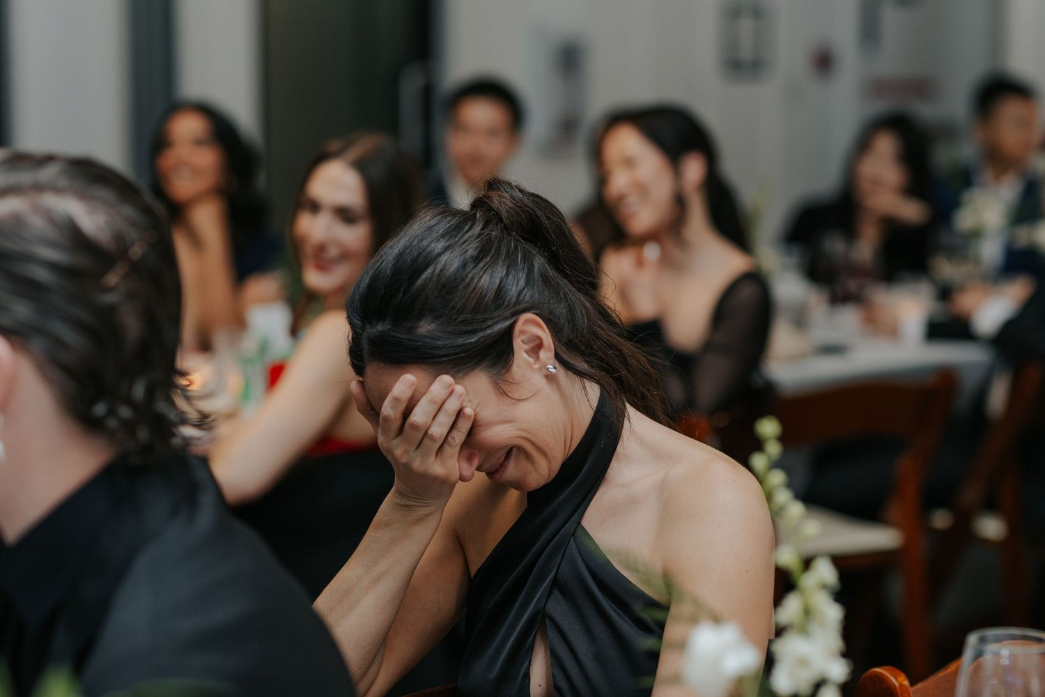 Candid moment of laughter and joy captured during a wedding reception celebration.