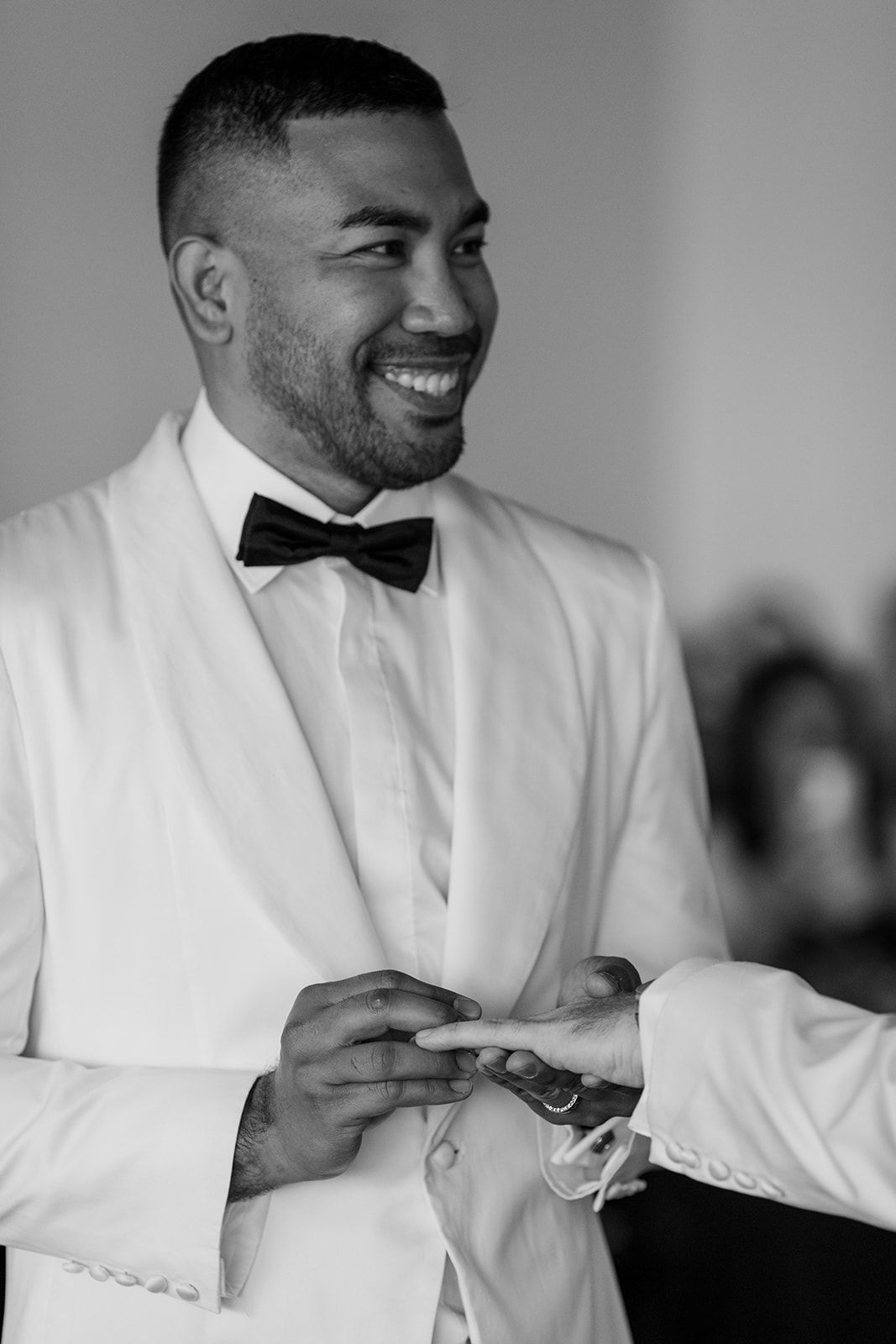 Series of black and white photos showing preparations in a white suit and bow tie.