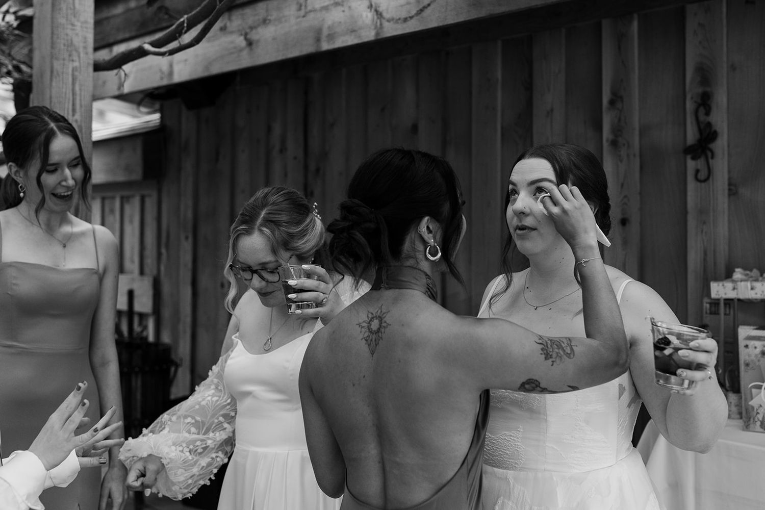 Black and white candid moment of wedding celebration with joyful expressions.