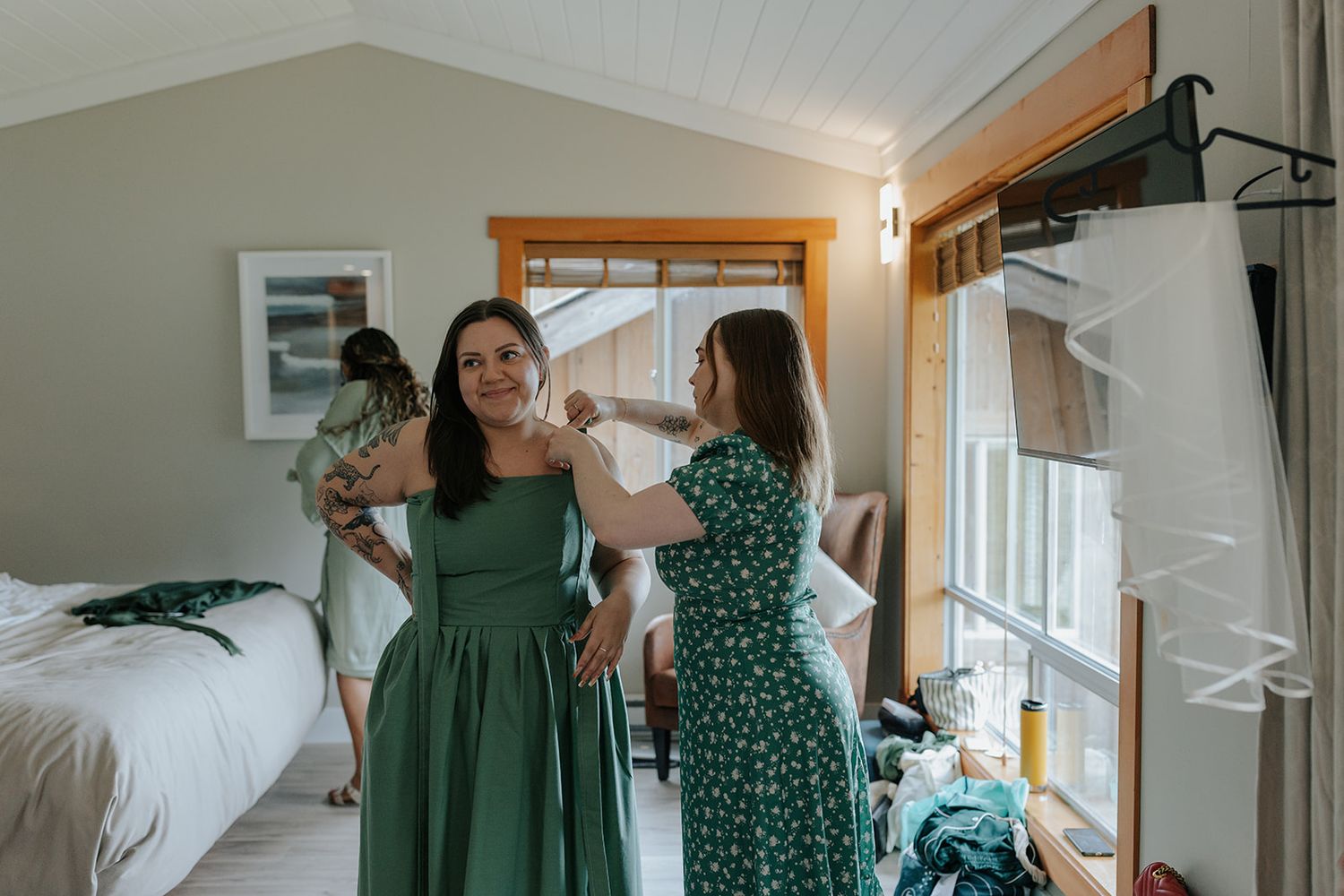 Wedding party members in emerald green polka dot dresses and white gowns gather indoors.