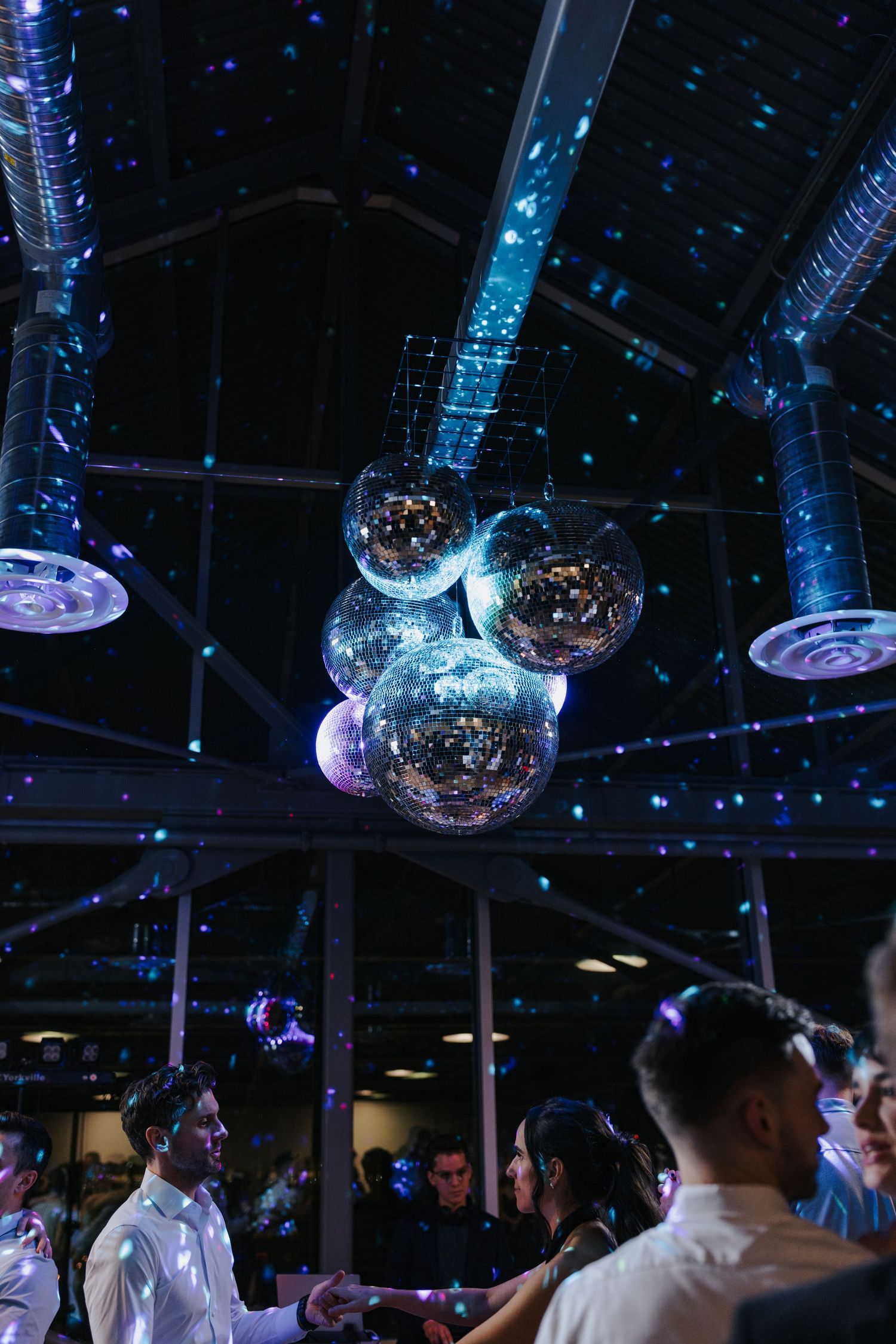 Nightclub scene with disco balls and blue lighting creating an atmospheric dance environment.