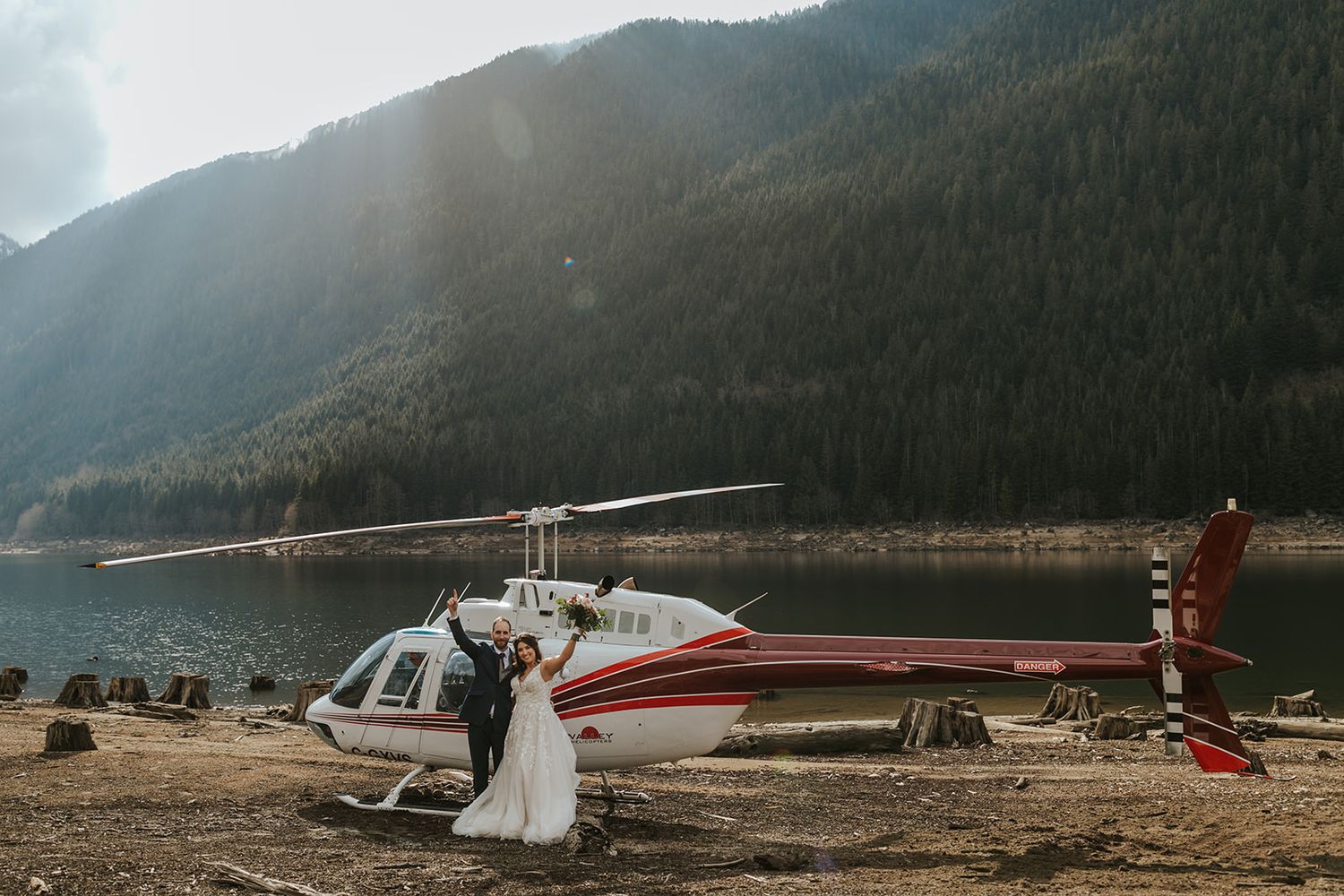 Helicopter landing on a scenic mountain lake shore with dramatic landscape.