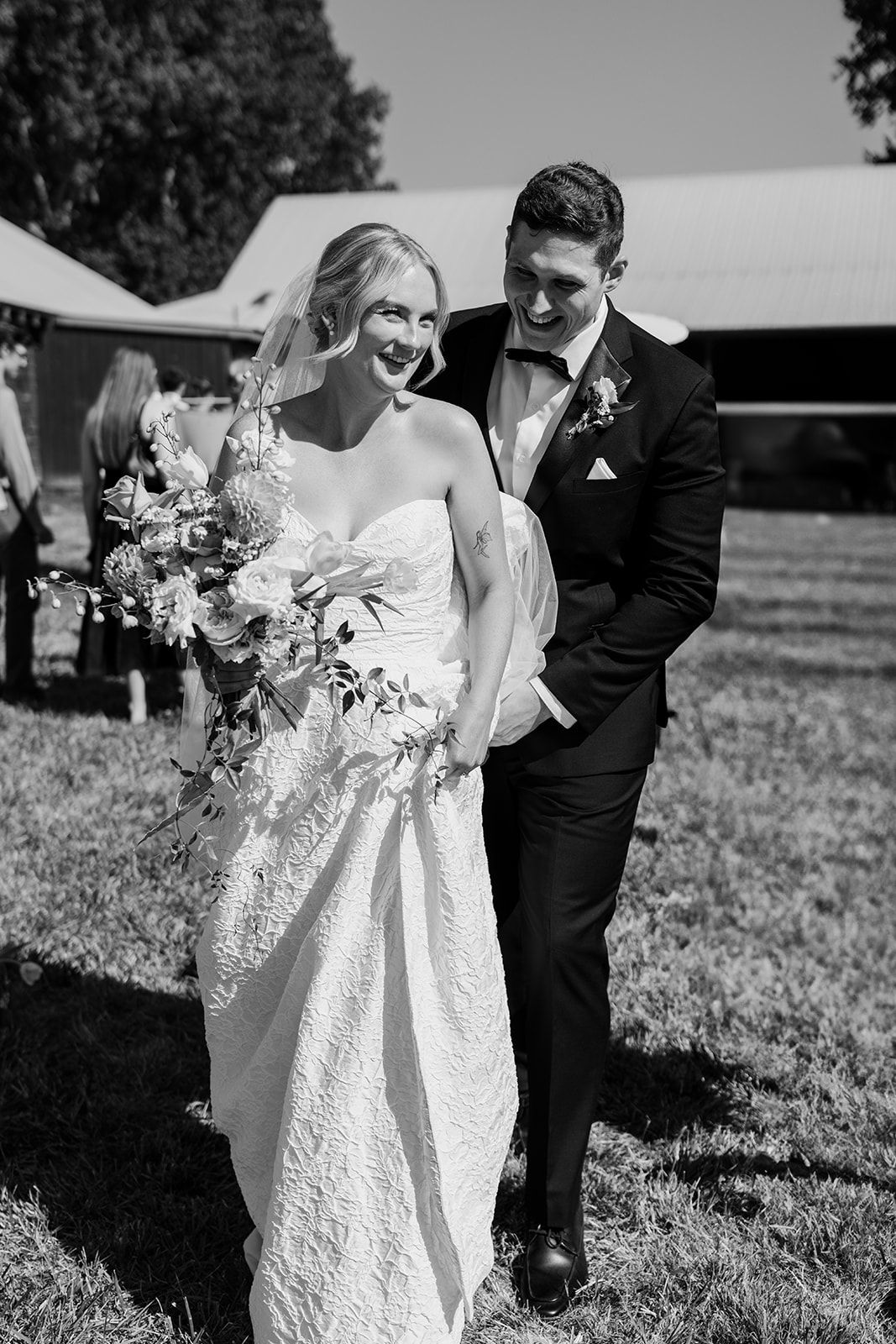 A black and white photo of a couple sharing a tender moment during their outdoor wedding.